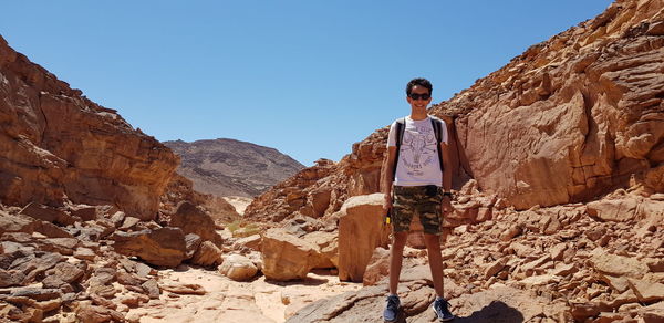 Full length of teenage boy standing at desert