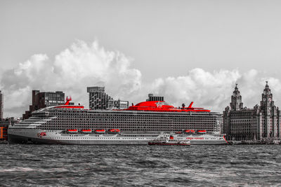 Ship by sea against buildings against sky