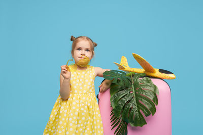 Portrait of girl standing against blue background