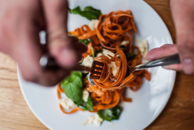 Cropped image of hands having pasta in restaurant