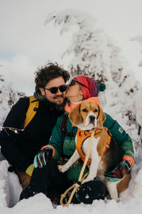 Portrait of a couple and a dog on snow