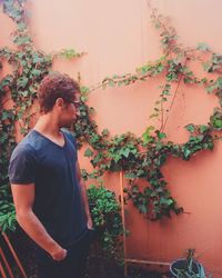 Man looking at ivy on coral wall