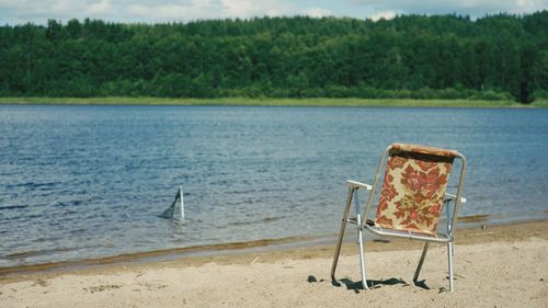 Chair on beach against sea