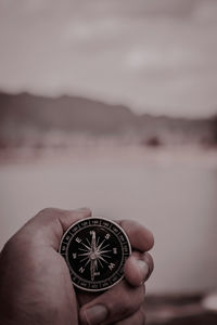 Close-up of hand holding navigational compass