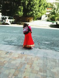 Rear view of woman walking on road