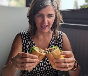 A woman admiring her delicious looking sandwich 