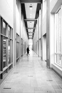 Rear view of man walking on corridor