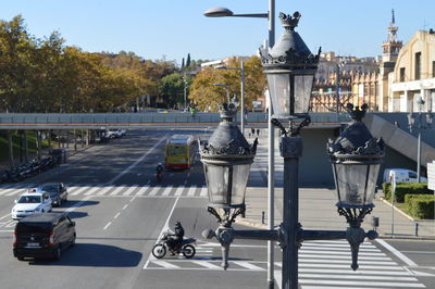 Vehicles on road against buildings in barcelona sunny day