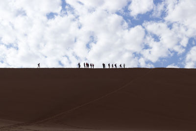 People on desert against sky