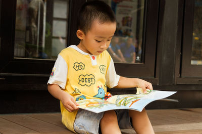 Boy sitting on paper