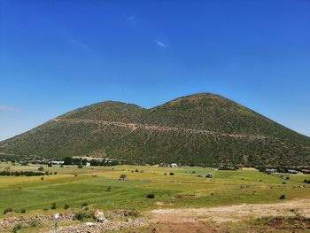 Scenic view of field against blue sky