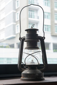 Close-up of lamp on window sill