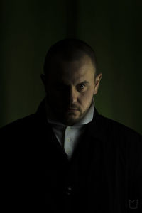 Portrait of man against black background