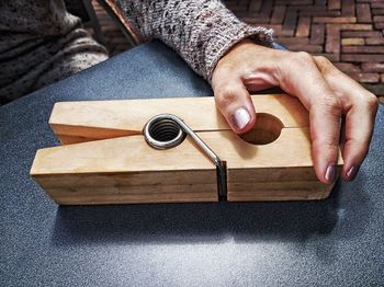 Close-up of woman holding wooden clothespin on table