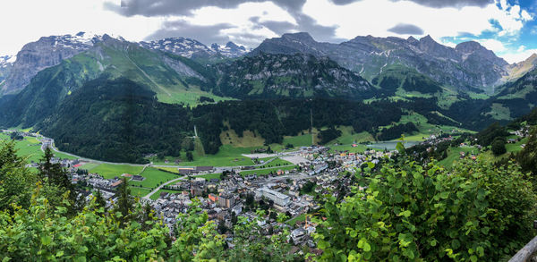 Scenic view of mountains and houses against sky