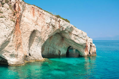 Scenic view of rock formation in sea against sky