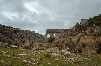 Low angle view of old ruin building against cloudy sky