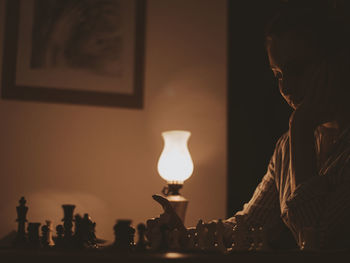 Young woman playing chess at home