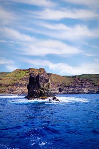 Rock formations by sea against sky