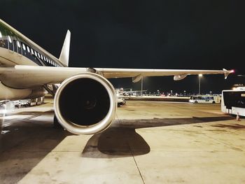 Airplane on runway against sky at night