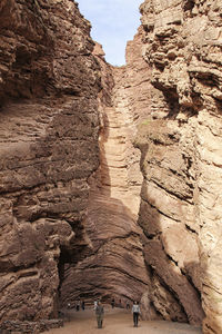 Low angle view of rocks on cliff against sky