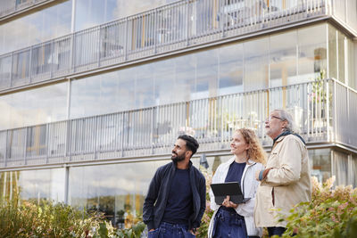 Men and woman with laptop looking at buildings