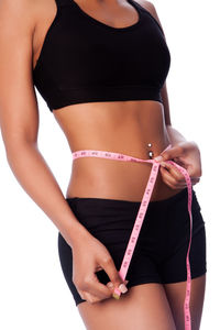 Midsection of young woman standing against white background