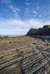 Scenic view of rocky beach against sky