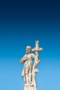 Low angle view of statue against blue sky