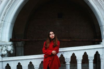 Full length of woman standing by railing in winter