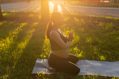 Full length of pregnant woman meditating at park