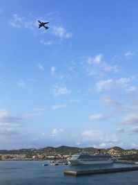 Airplane flying over sea against sky