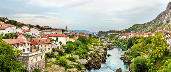 River amidst buildings in town against sky