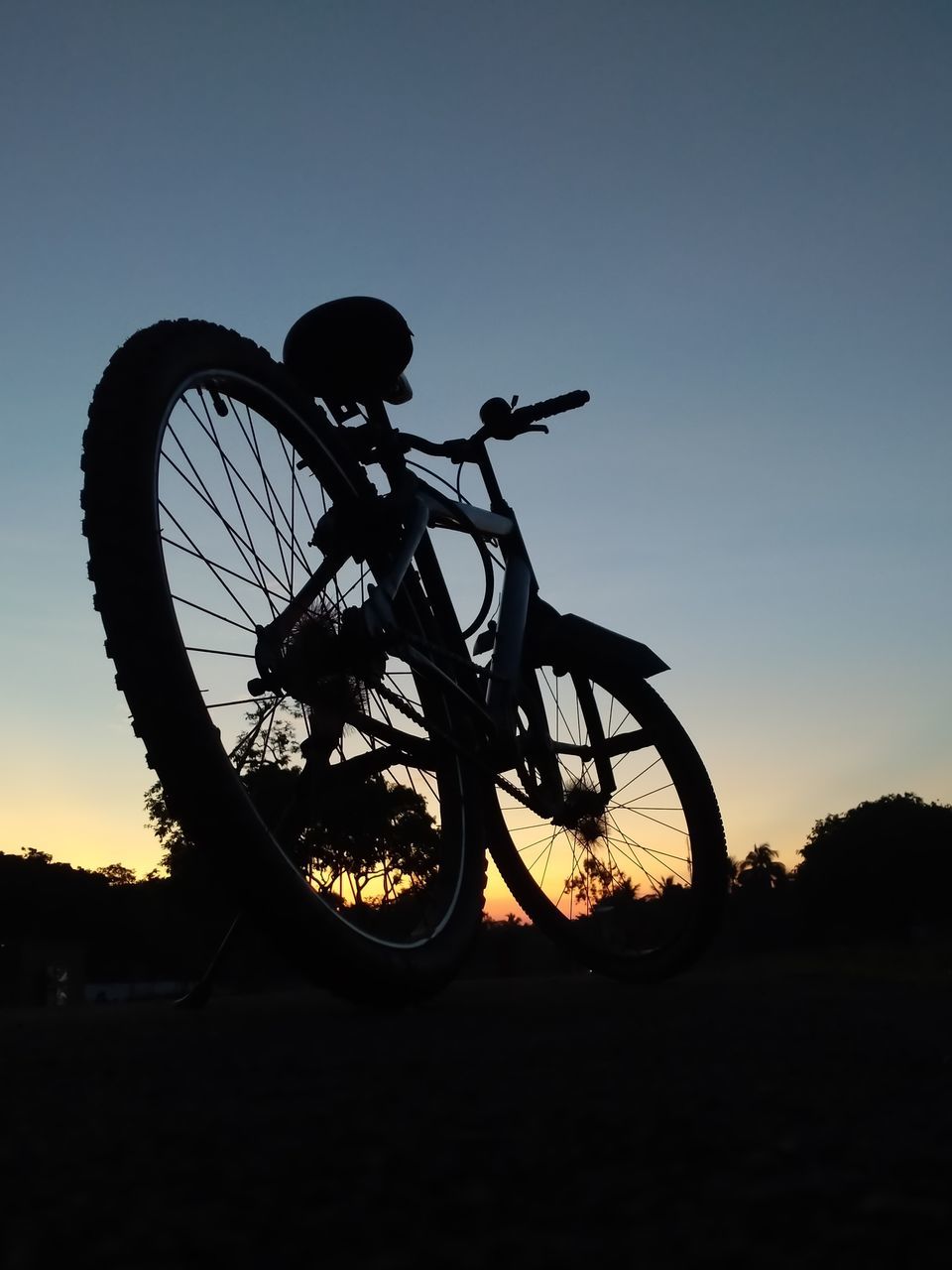 silhouette, transportation, sky, bicycle, nature, vehicle, sunset, sports equipment, mountain bike, sports, mode of transportation, activity, wheel, dusk, cycle sport, copy space, cycling, mountain biking, outdoors, one person, land, clear sky, motion, sunlight, back lit, pedal, land vehicle