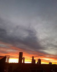 Silhouette of buildings against cloudy sky