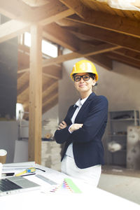 Architect wearing hardhat while working at construction site