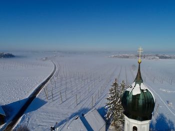 Panoramic view of church covered with snow against sky