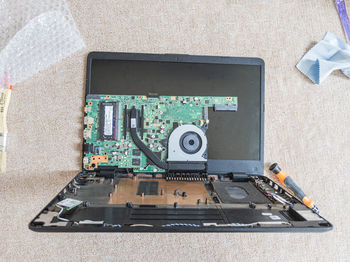 High angle view of laptop equipment on table while cleaning.