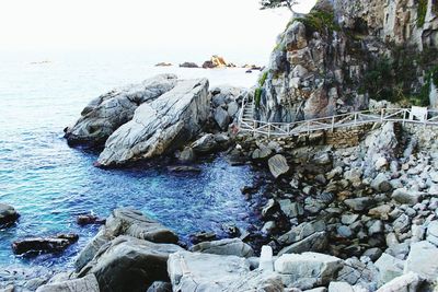 Rocks by sea against sky