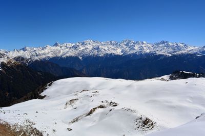 Scenic view of snowcapped mountains against clear blue sky