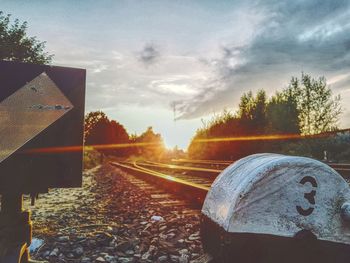 Close-up of railroad track against sky during sunset