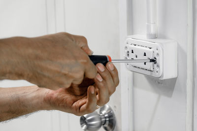 Cropped hands of electrician repairing electrical equipment