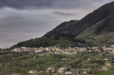 Aerial view of townscape by mountain against sky