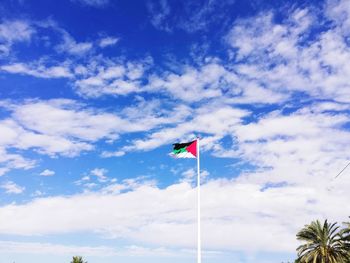 Low angle view of flag against blue sky