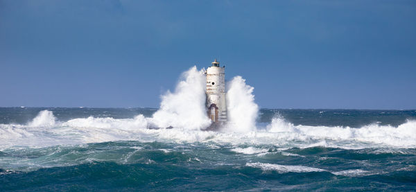 Water splashing in sea against clear blue sky