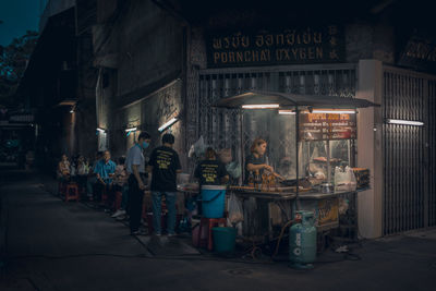 Group of people in front of illuminated building at night