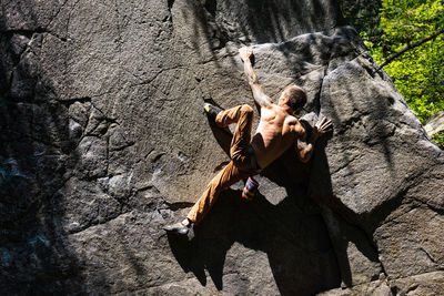 Climber using heel hook to get to the top of the boulder