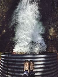 Low section of man on top of water pipe