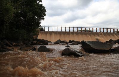 Scenic view of dam and rocks against sky