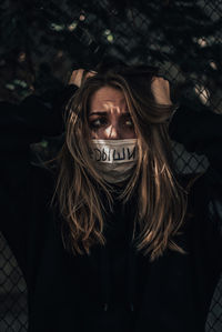 Woman with hands in hair standing outdoors